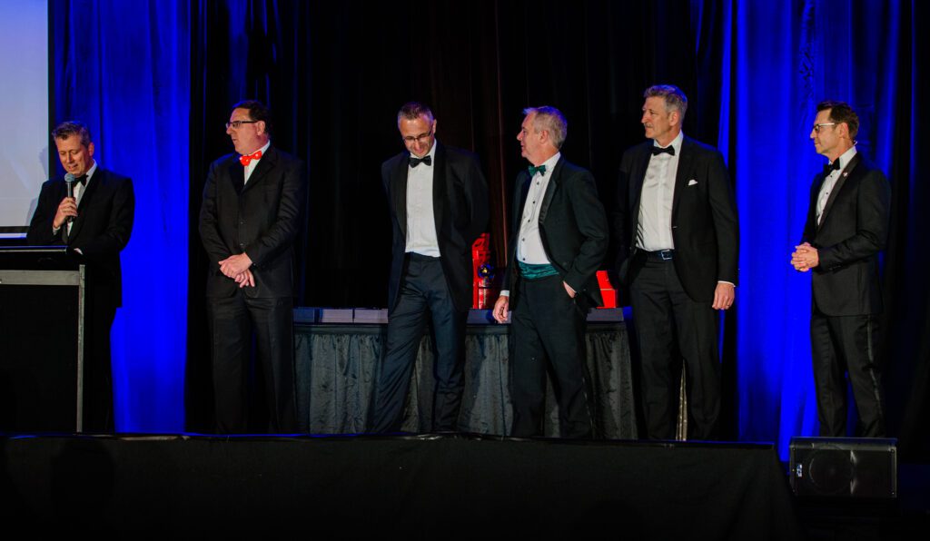 Abundance Global Nick Farrow [left] and David Dugan [right] present BidWrite directors [centred L-R] Nigel Dennis, Rodger Manning, David Harvey and David Lunn with the ‘Big Leap’ Award.