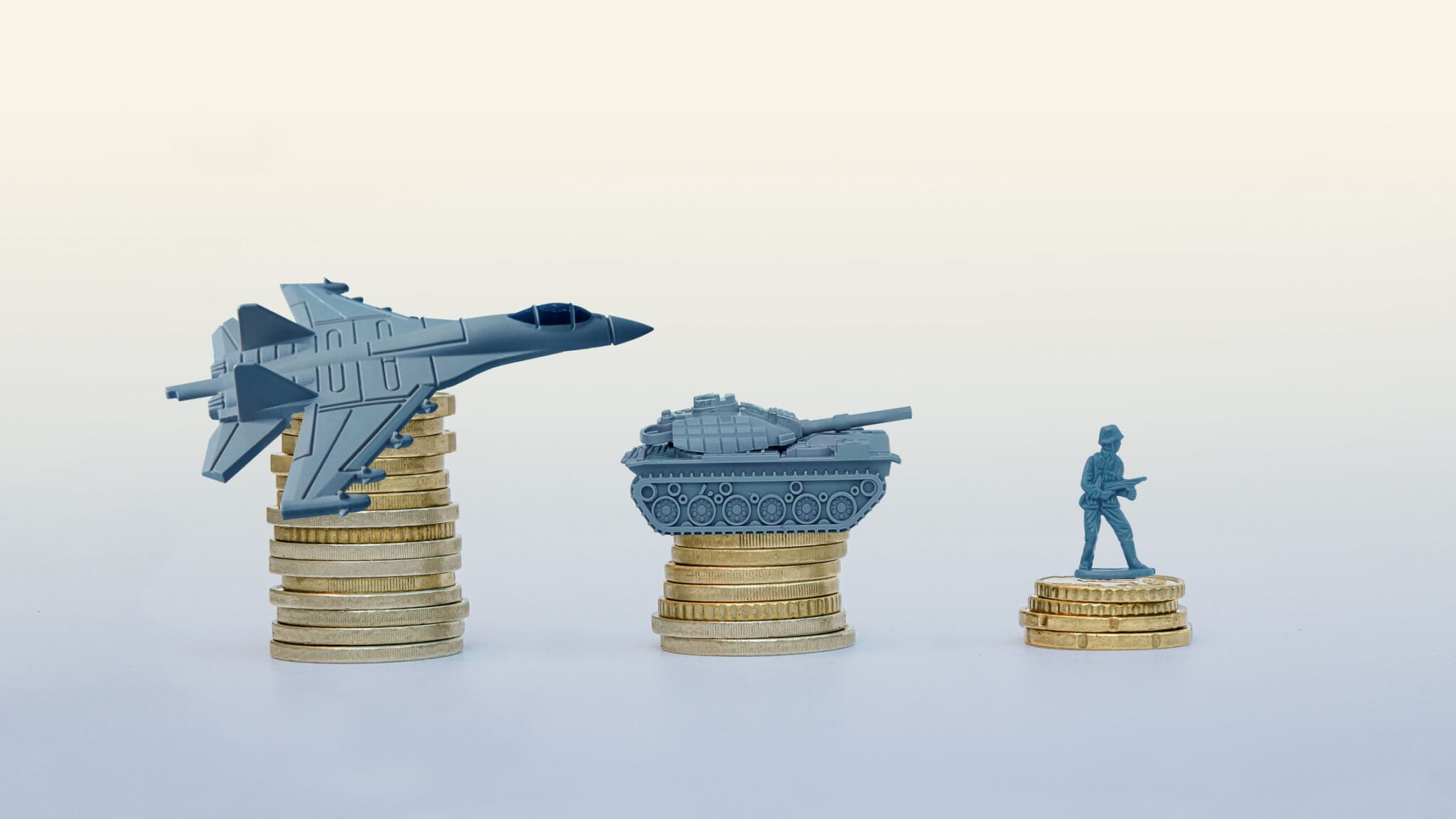 Defence/army/navy figurines placed upon stack fo coins, representing the cost of Defence bidding